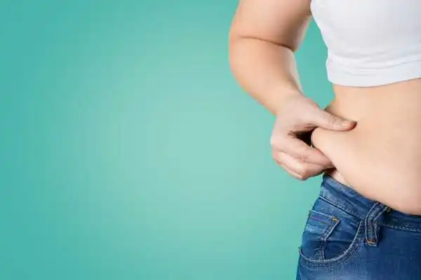 Image of woman pinching her love handles to show weight gain Ravenscliffe